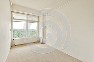 an empty living room with a window and white walls