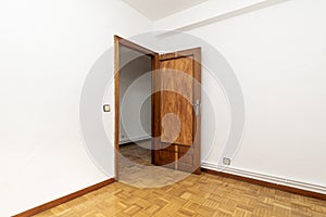 Empty living room with wooden door, oak parquet flooring