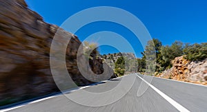 Empty long mountain road to the horizon on a sunny summer day at bright sunset