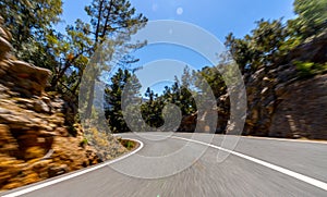 Empty long mountain road to the horizon on a sunny summer day at bright sunset