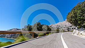 Empty long mountain road to the horizon on a sunny summer day at bright sunset