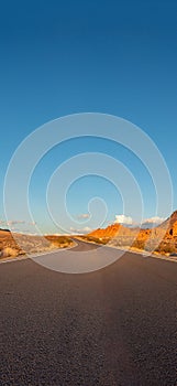 Empty long nevada mountain road to the horizon on a sunny summer day at bright sunset. vertical image for your reel and story