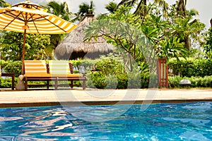 Empty lounge chairs by the crystal blue pool on Hainan Island.