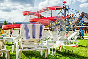 Empty lounger and water slide in aquapark