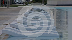 empty lounger in water of swimming pool of luxury hotel, travelling and rest in summer holidays