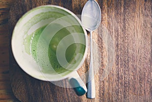 Empty matcha latte green tea cup on a wooden board