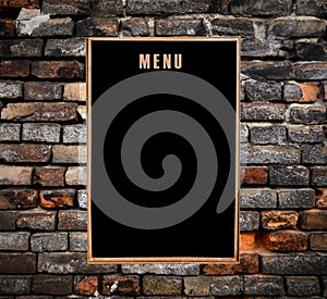 Empty menu board hanging on grunge brick wall