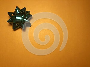 Empty message area with ornament as green bright star, note paper or frame on dark and light orange background.