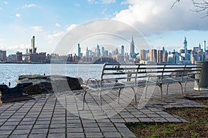 Empty Bench at Bushwick Inlet Park in Williamsburg Brooklyn New York along the East River with a view of the Manhattan Skyline photo