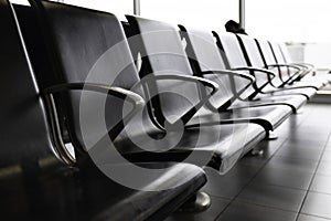 Empty metal seats with black leather seat in the public area at an airport