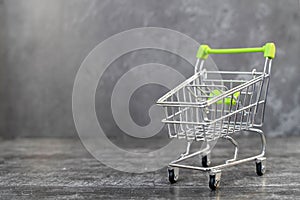 Empty metal shopping cart in a supermarket, side view