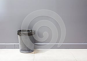 An empty metal trashcan (bin) isolated on gray