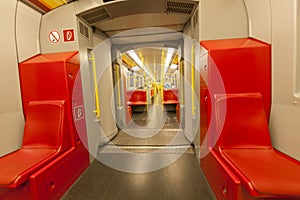 Empty metro train interior with red seats, city transport