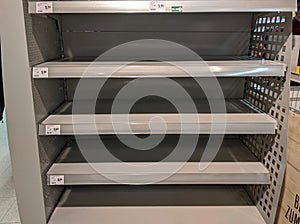 Empty milk shelves in supermarket after panic buying due to outbreaking coronavirus translation:`There is no stock available due t photo