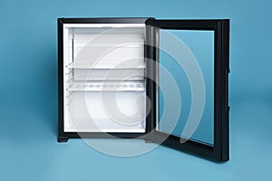 Empty mini bar with open glass door on turquoise background
