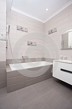 Empty minimalistic interior background, bathroom of modern apartment, mirror, bathtub and basin in light colors