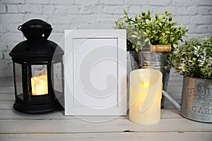 Empty mockup photo frame with LED candlelight on white brick wall background