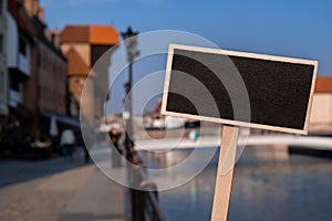 Empty mockup template Blackboard label against Gdansk beautiful old town over Motlawa river. The Zuraw Crane and