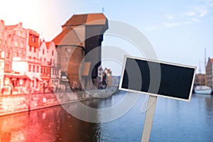 Empty mockup template Blackboard label against Gdansk beautiful old town over Motlawa river. The Zuraw Crane and