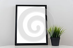 Empty Modern Black Frame On White Glossy Table With Decorative Grass In Flowerpot Light Gray Background Wall White Blank