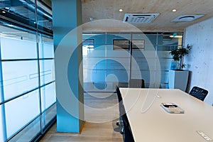 Empty modern board room with conference table and glass walls in office