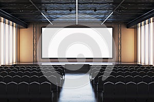 Empty modern conference hall with large blank screen and black chairs arranged in rows for corporate presentation or business