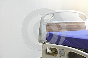 An empty modern electric hospital bed or patient`s bed in hospital ward over white background, copy space