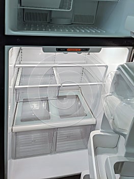 Empty, modern refrigerator with opened doors. Inside of a clean fridge with plastic shelves