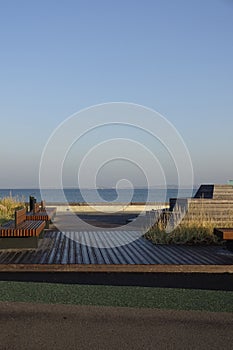 Empty modern wooden bench on the Reidi promenade (estonian Reidi tee) on the shore of Baltic sea. Cloudy summer day