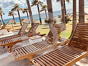 Empty modern wooden sunbeds by turquoise swimming pool. cyprus. empty hotel in quarantine period before opening