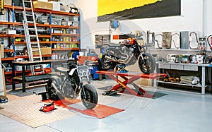 Empty motorcycle workshop with custom motorbikes over platforms ready to repair