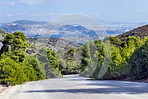 Empty mountain road with blue sky and sea on a background. Greece, island of Salamina.