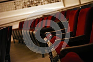 Empty movie theater auditorium with fancy red chairs