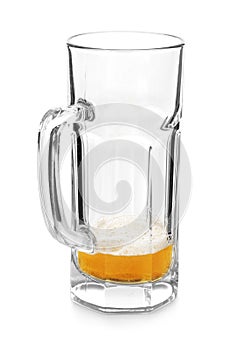 Almost empty mug of cold beer on white background