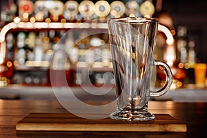 Empty mug standing on a wooden board in a pub.