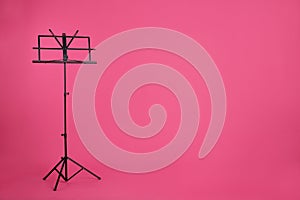 Empty music note stand on color background