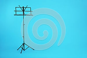 Empty music note stand on color background