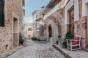 Empty narrow cobbled street in small spanish village with typical houses