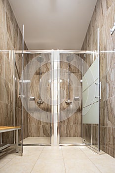 Empty new double shower cabins inside a fitness center, no people