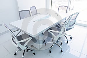 Empty new meeting room with magnificent view from the window. Office chairs and conference table in the office. Business or office