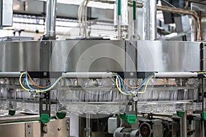 Empty new plastic bottles on conveyor line in factory for production drink water, juices and other beverage