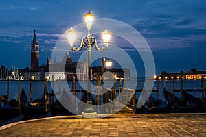 Empty, no tourists Venice. Gondolas moored by Saint Mark square with San Giorgio di Maggiore church photo