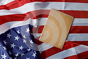 An empty notebook on the background of the American flag. Space for text. Close-up