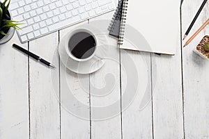 Empty notebook, computer and coffee on wooden