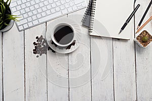 Empty notebook, computer and coffee on wooden table