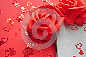 empty notebook next to red roses