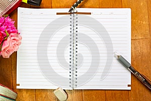 Empty notebook and pen on wooden table with copy space