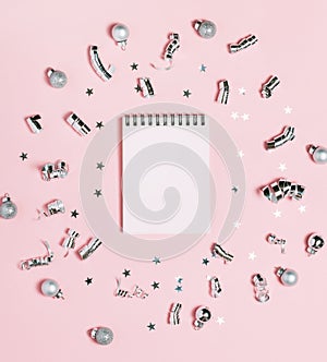 Empty Notebook on pink background with silver Christmas decoration. Bright and festive. New Year concept, top view, flat lay