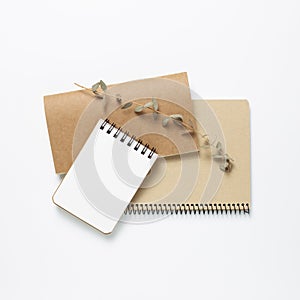 Empty notepad with eucalyptus leaves on white background