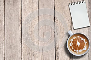 Empty notepad and hot coffee on desk, top view, copy space